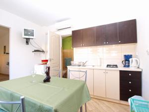 een keuken met een tafel met een groene tafelkleed erop bij Apartments Nadia 1493 in Medulin