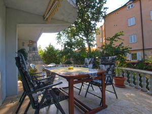een houten tafel en stoelen op een patio bij Apartments Nadia 1493 in Medulin