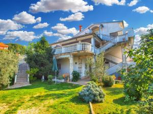 een groot huis met een balkon en een tuin bij Apartments Nadia 1493 in Medulin