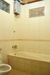 a bathroom with a bath tub and a toilet at Nyoman Murjana Homestay in Ubud