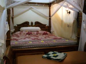 a bedroom with a bed with a canopy at Nyoman Murjana Homestay in Ubud +18 photos