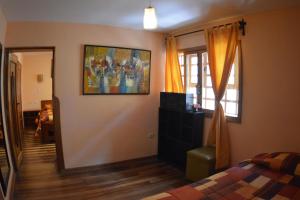 sypialnia z łóżkiem i obrazem na ścianie w obiekcie Departamentos Cusco w Cuzco