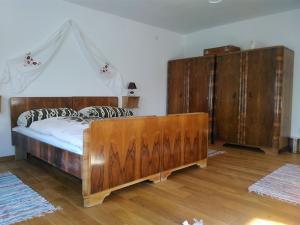 a bedroom with a large wooden bed and wooden cabinets at Nađ Holiday Home in Privlaka