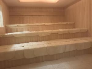 Capsule&Spa Grand Sauna Hiroshima (Male Only) في هيروشيما: غرفة مع رفوف خشبية في خزانة
