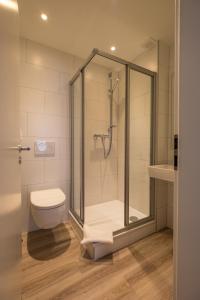 ein Bad mit einer Dusche und einem WC in der Unterkunft Hotel Cityroom in Gelsenkirchen
