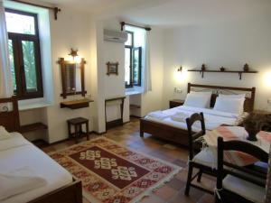 a bedroom with two beds and a table and windows at Hotel Happy Caretta in Dalyan