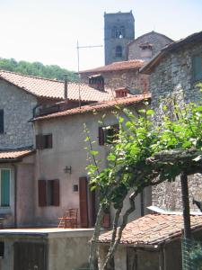 ein Gebäude mit einem Uhrturm im Hintergrund in der Unterkunft Tuscany Village Hideaway in Motrone