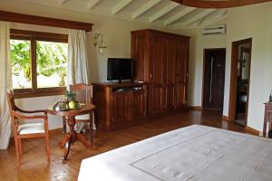 a living room with a television and a table with a chair at Ocean Beach Resort & SPA in Malindi