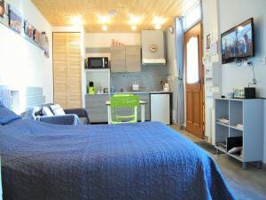 una camera con letto blu e una cucina di Studio RIGA ad Ax-les-Thermes