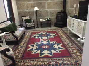 uma sala de estar com um tapete e um fogão em Quinta da Cartida em Santa Marinha do Zêzere