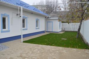 ein weißes Haus mit einem Garten mit einem Baum in der Unterkunft Dream House in Bălţi