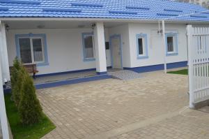 ein weißes Haus mit einem blauen Dach und einer Terrasse in der Unterkunft Dream House in Bălţi