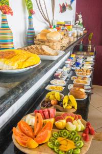 a buffet line with different types of food on plates at Pousada É in Cumuruxatiba