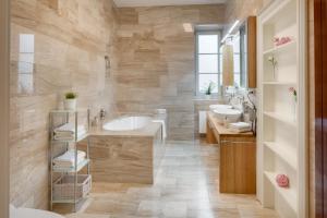 une salle de bain avec deux lavabos et une baignoire dans l'établissement Smetanovo nábřeží - Riverview Old Town Apartment, à Prague