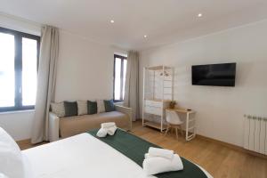 a white bedroom with a bed and a couch at Colosseo Guest House in Rome