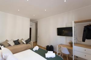 a bedroom with a bed and a couch and a desk at Colosseo Guest House in Rome