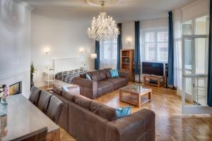 uma sala de estar com sofás e um lustre em Smetanovo nábřeží 26 - Riverview Old Town Apartment em Praga