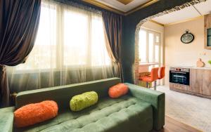 uma sala de estar com um sofá verde com almofadas coloridas em Unique atmosphere with golden standard design em Sófia