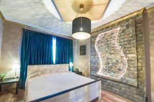 una camera con letto e parete in pietra di Unique atmosphere with golden standard design a Sofia