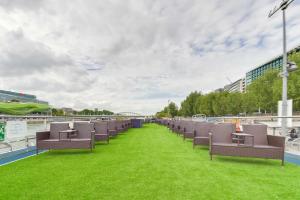 - une rangée de chaises sur un balcon avec pelouse dans l'établissement VIP Paris Yacht Hôtel & Spa, à Paris