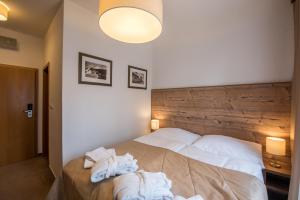 a bedroom with a bed with towels on it at Šport Hotel *** Donovaly in Donovaly