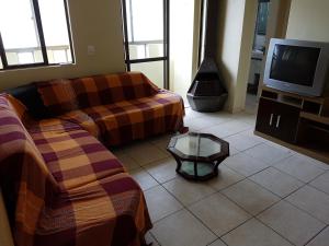 Una sala de estar con dos sofás y un televisor. en Capao da canoa Apto. 3 dorm, en Capão da Canoa