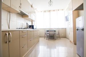 a kitchen with white cabinets and a table and a window at Апартаменты на ул. Помирецкая 9 in Truskavets