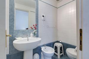 un bagno blu e bianco con lavandino e servizi igienici di ROMA CENTER, Rione Monti, Apartament a Roma