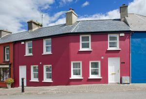 a red and blue house with a white door at RossNua in Rosscarbery