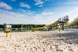 un parque infantil con un tobogán en una playa de arena en Holidaypark Klein Strand, en Jabbeke