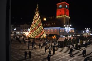 Un árbol de Navidad en medio de una ciudad por la noche en Casa Krone - Piața Sfatului, en Brasov