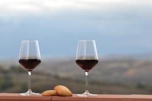 two glasses of wine and some cookies on a table at Relax in Maremma tra Saturnia e Argentario in Pancole