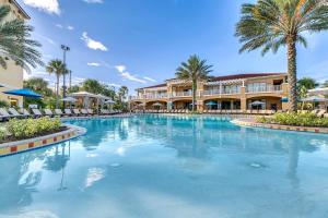 a large swimming pool at a resort with palm trees at Disney Themed Family Villa, Waterpark & Resort Amenities Included in Kissimmee