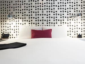 - une chambre avec un lit blanc et un oreiller rouge dans l'établissement Dream Downtown, by Hyatt, à New York