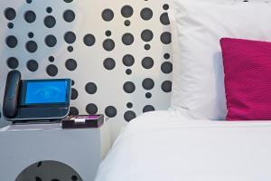 a bedroom with a bed with a laptop on a night stand at Dream Downtown, by Hyatt in New York