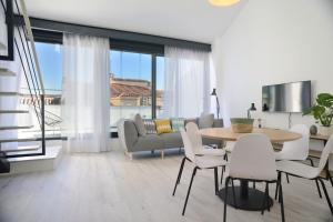 a living room with a table and chairs and a couch at Aspasios Atocha Apartments in Madrid