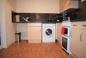 a kitchen with a washing machine and a washer at Kelpies Serviced Apartments Callum- 3 Bedrooms- Sleeps 6 in Livingston