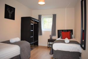 a bedroom with two beds and a window at Kelpies Serviced Apartments Callum- 3 Bedrooms- Sleeps 6 in Livingston