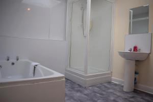 uma casa de banho branca com uma banheira e um lavatório em Kelpies Serviced Apartments Callum- 3 Bedrooms- Sleeps 6 em Livingston