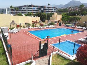 
a swimming pool with a tennis court and a tennis racquet at El Cortijo Luxury in Playa de las Americas
