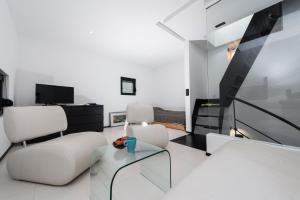 a living room with two white chairs and a glass table at Villa Kula in Dragove