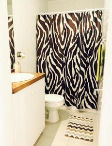 a bathroom with a zebra shower curtain and a toilet at Apartamentos Nevados de Pucón in Pucón