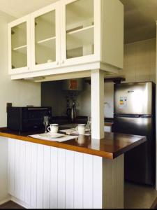a kitchen with white cabinets and a black refrigerator at Apartamentos Nevados de Pucón in Pucón