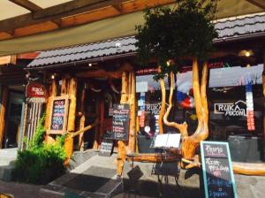 a restaurant with two trees in front of a building at Apartamentos Nevados de Pucón in Pucón