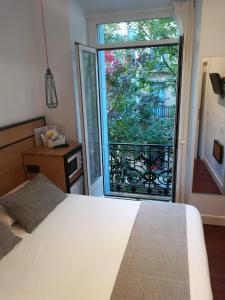 ein Schlafzimmer mit einem Bett und einem großen Fenster in der Unterkunft Pensión La Perla in San Sebastián