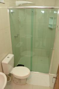 a bathroom with a toilet and a glass shower at Hotel Icamiabas in Parintins
