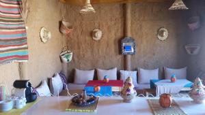 a room with a table and chairs in a room at SaharaTime Camp in Adrouine