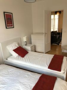 パリにあるMarché St-Honoréのベッドルーム1室(白いベッド1台、赤いタオル付)