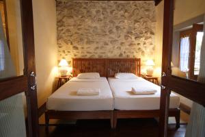 a bedroom with two beds and two lamps on the wall at Sala Prabang Hotel in Luang Prabang
