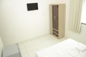 um quarto branco com uma cama e um armário em Hotel Icamiabas em Parintins